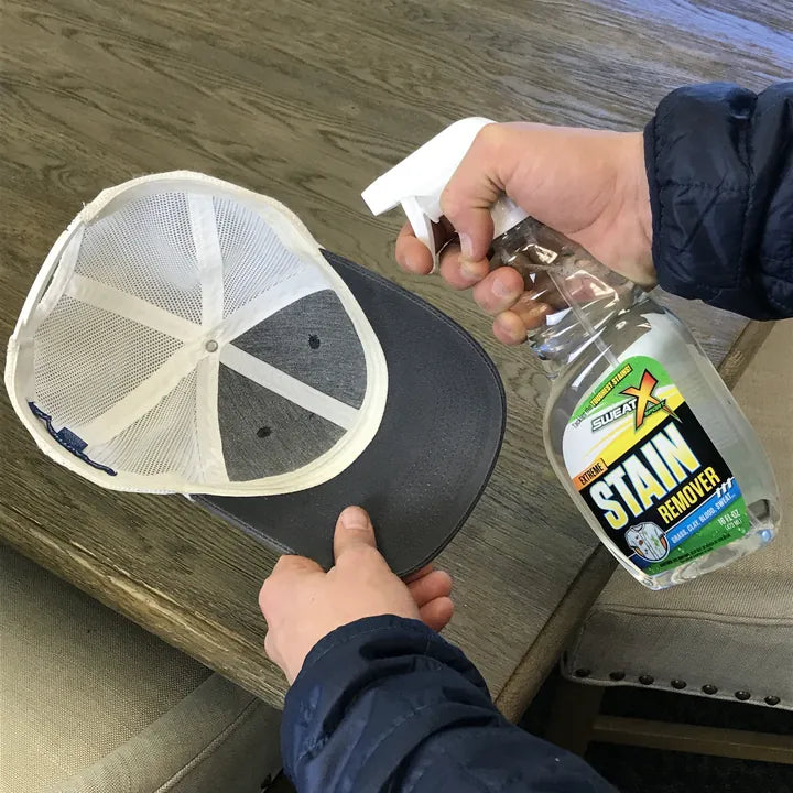 Spraying the inside sweatband of a baseball cap