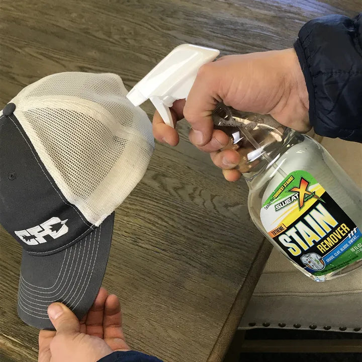 Spraying Extreme Stain Remover on the mesh of a baseball cap